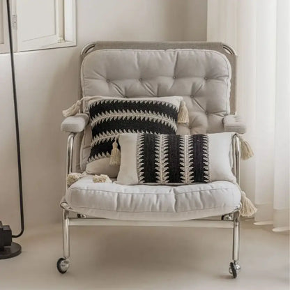 A sleek armchair with tufted beige upholstery and chrome legs complements decorbites jacquard crochet pillow covers