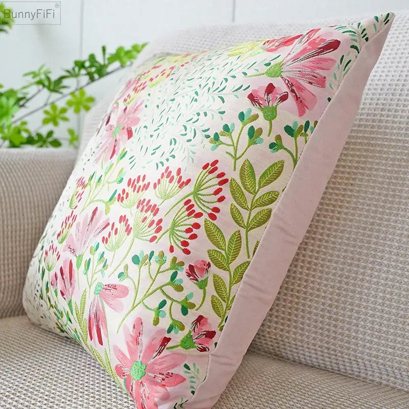 A soft jacquard floral pillow cover with pink blossoms and green foliage on an off-white background for bedroom decor