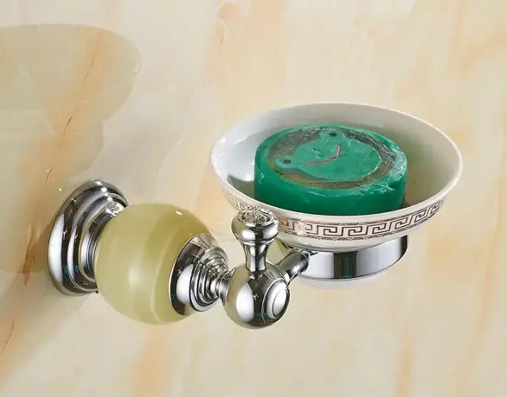 Chrome-finished soap dish with a jade bathroom set featuring a pale green frog-shaped soap in a white ceramic bowl with greek key detailing