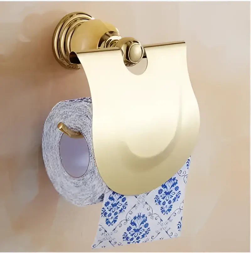 Gold-colored metallic toilet paper holder with sleek curved design from jade gold bathroom accessories set with amber marble