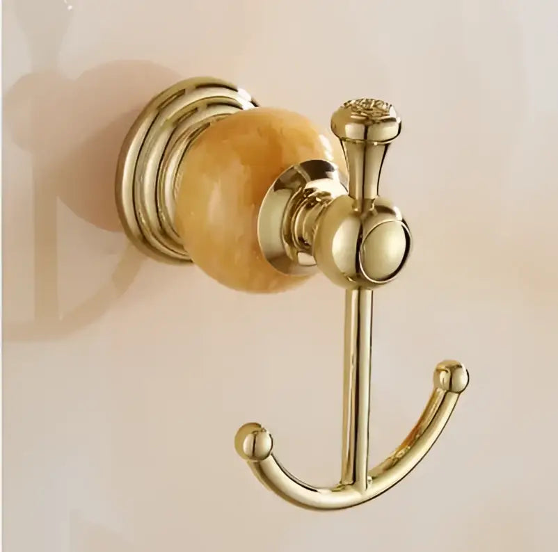 Gold-toned bathroom hook with polished amber stone and ornate curved design from jade gold bathroom accessories set