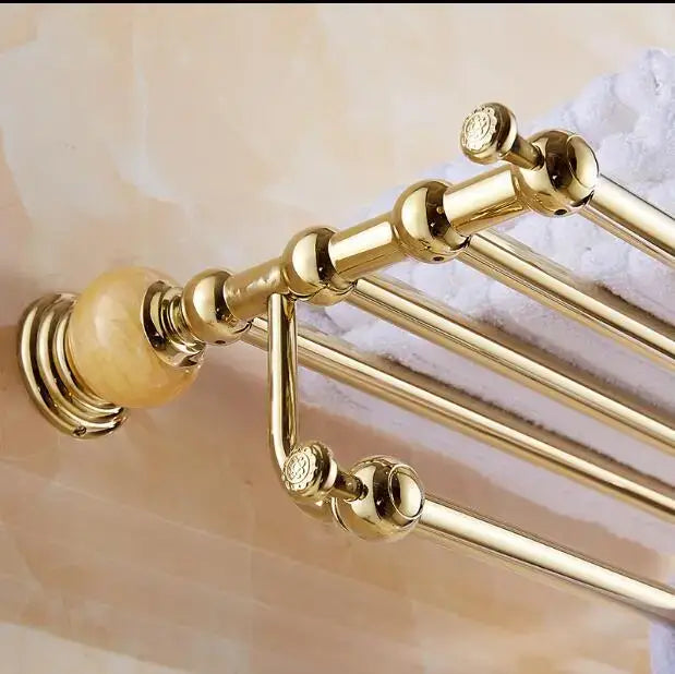 Gold-toned bathroom towel rack with ornate spherical finials and polished brass finish in jade gold bathroom accessories