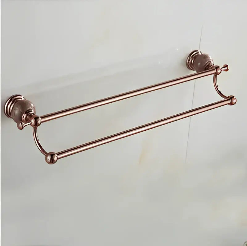 Rose gold double-tier towel rack with ornate spherical end caps in jade rose gold bathroom set with polished metal bars