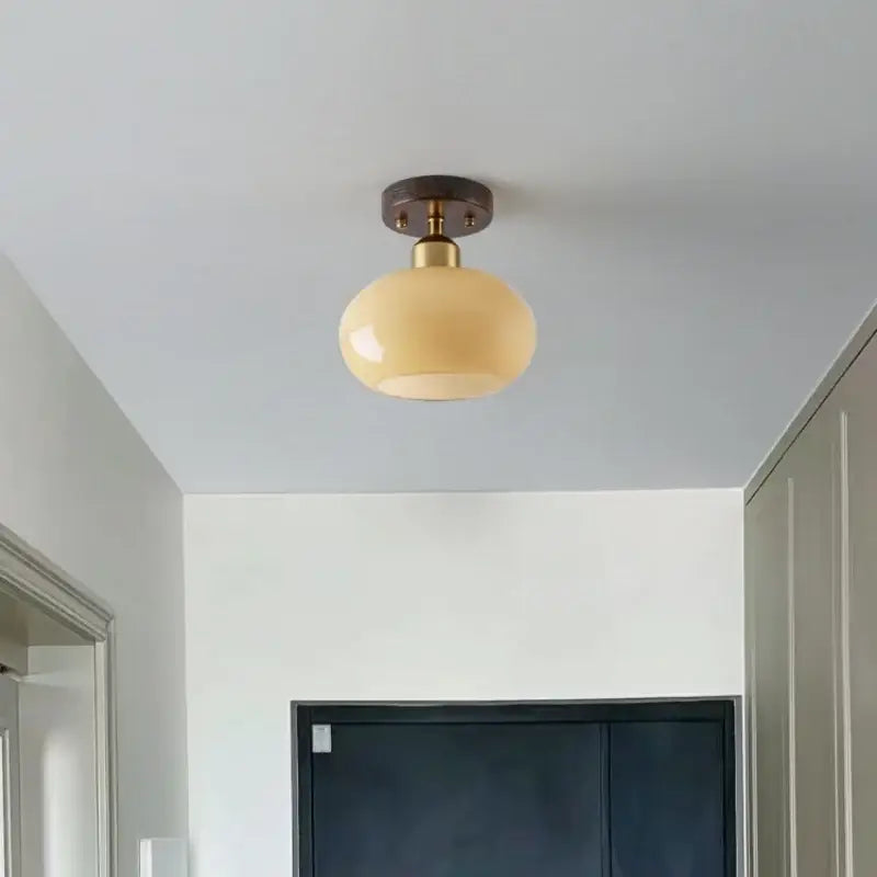 Cream-colored glass globe LED ceiling lamp with brass-finished metal base for decorbites LED ceiling lighting