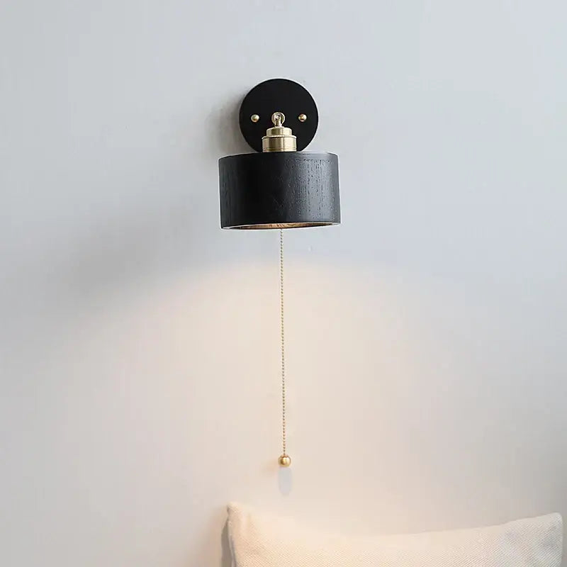 Black cylindrical Japanese wood wall light with brass accents and pull chain switch for bedroom decorbites wall lamp