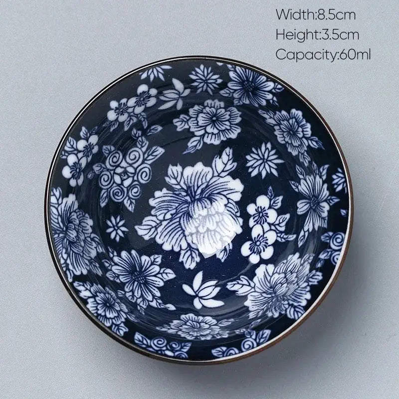 A navy blue ceramic kung fu tea cup with intricate white floral patterns and a metallic rim by decorbites ceramic