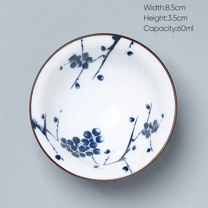 A white porcelain decorbites ceramic kung fu tea bowl with blue plum blossom patterns and a thin brown rim