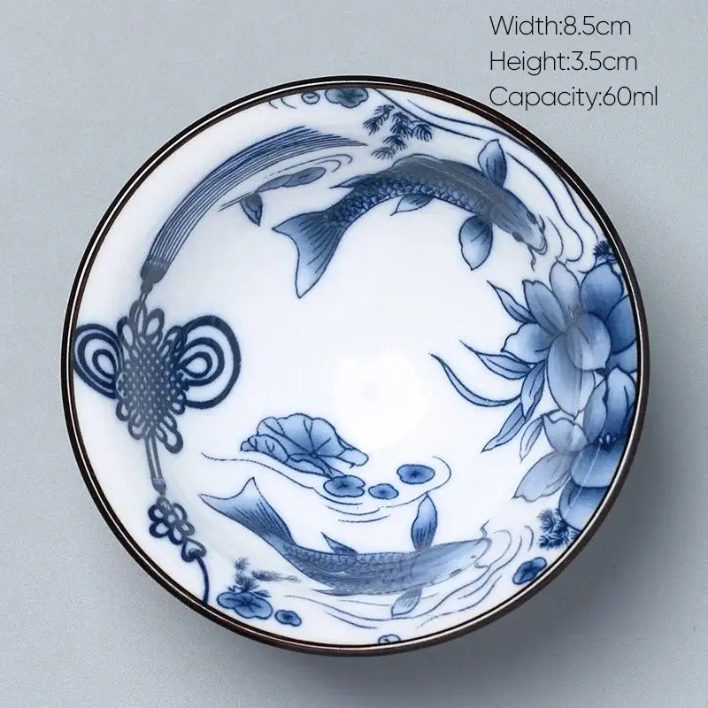 A delicate white and blue decorbites ceramic kung fu tea porcelain bowl with koi fish lotus and chinese knot designs