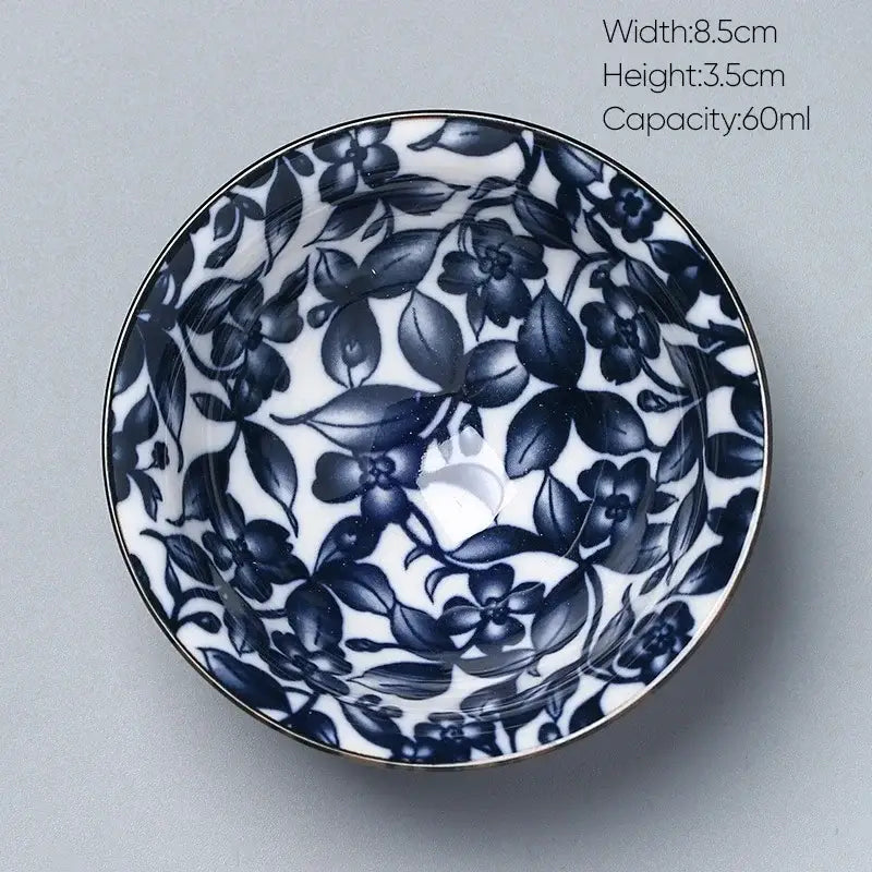 A delicate white porcelain kung fu tea cup with navy blue floral patterns and metallic rim by decorbites ceramic