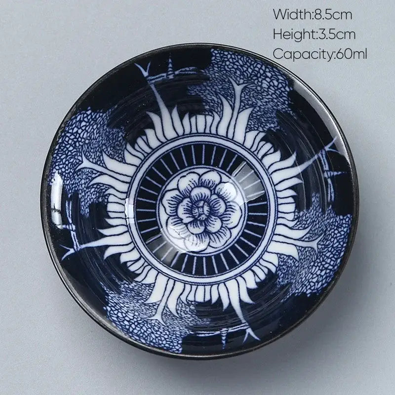A glossy navy blue decorbites ceramic kung fu tea porcelain bowl with intricate white floral and radiating patterns