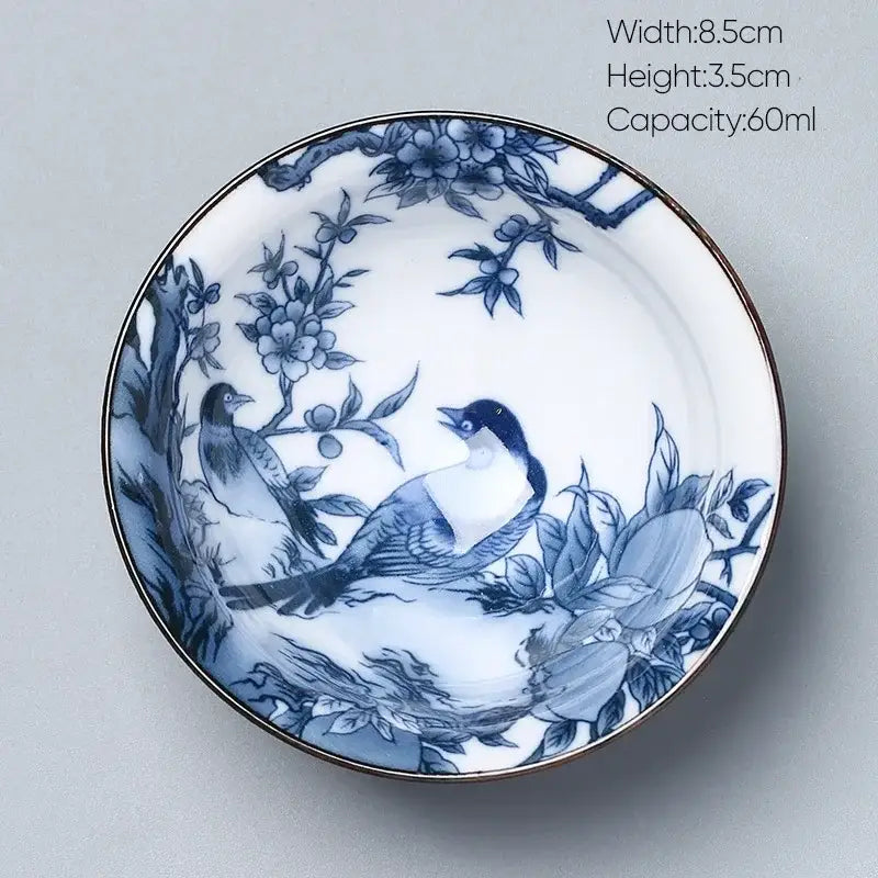 A delicate white porcelain kung fu tea cup with blue bird underglaze painting and gold rim from decorbites ceramic