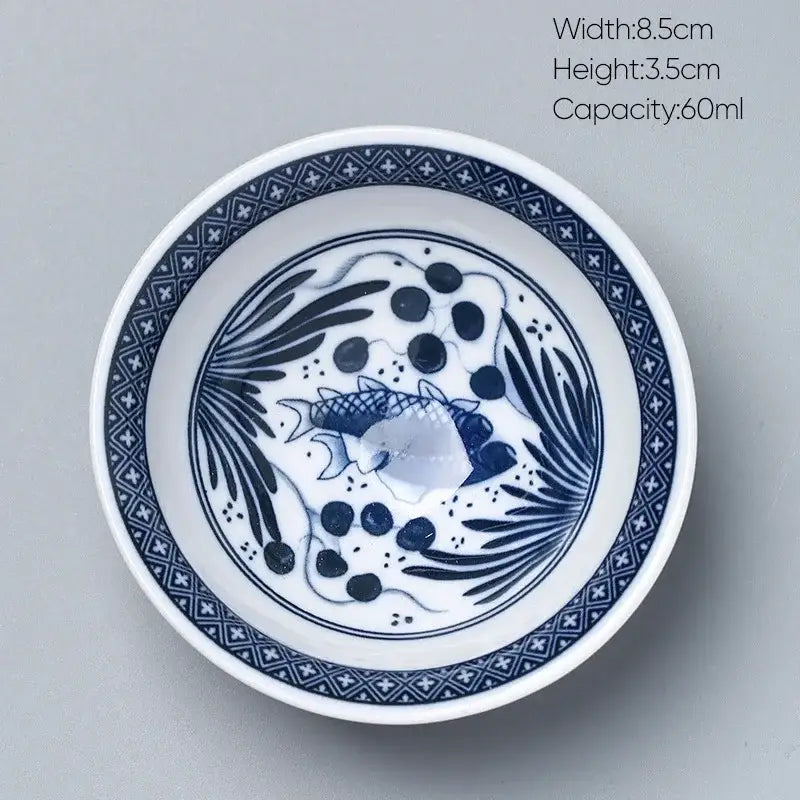 A white ceramic kung fu tea cup bowl with blue and white hand-painted fish and aquatic plant design by decorbites ceramic