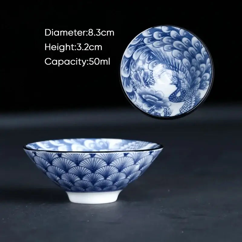 A delicate blue and white ceramic kung fu tea cup featuring intricate fan patterns outside and a peacock design inside
