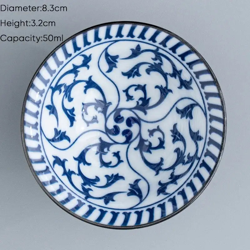 A delicate white ceramic kung fu tea cup with blue floral patterns and metallic rim for dining room use