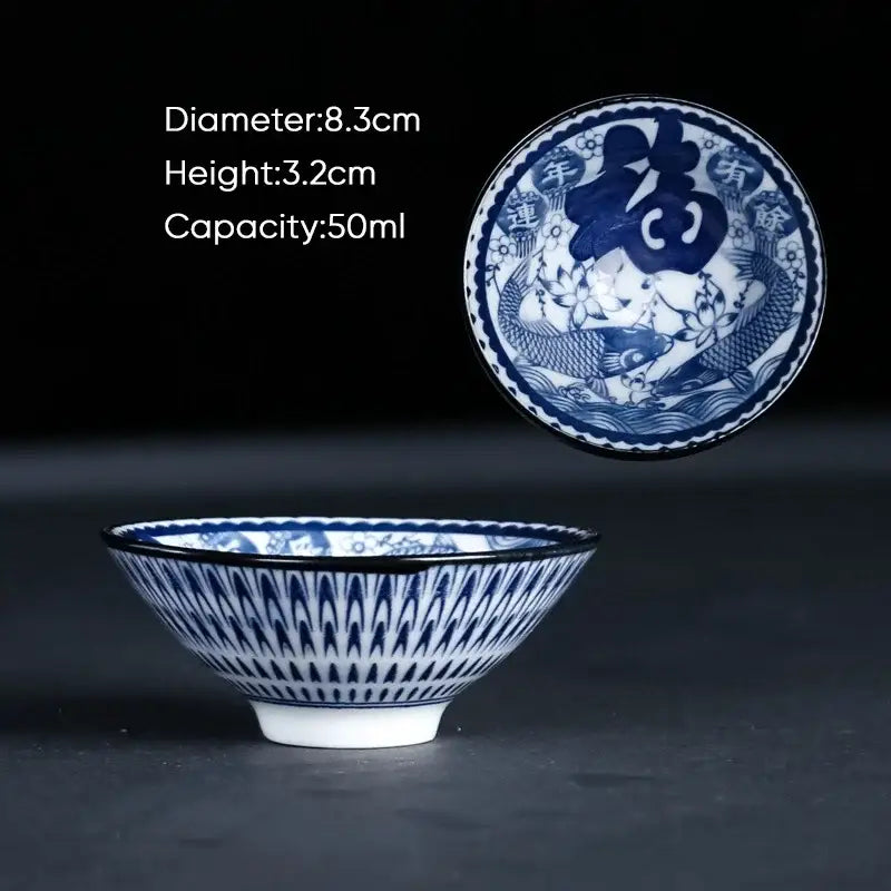 Traditional blue and white ceramic kung fu tea cup with intricate fish and lotus patterns and bold fu character lid