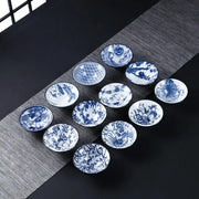 Set of ten blue and white ceramic kung fu tea cups with intricate floral fish bamboo and bird motifs for dining room use