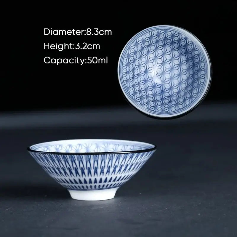 A delicate blue and white ceramic kung fu tea cup with intricate geometric patterns and a glossy finish