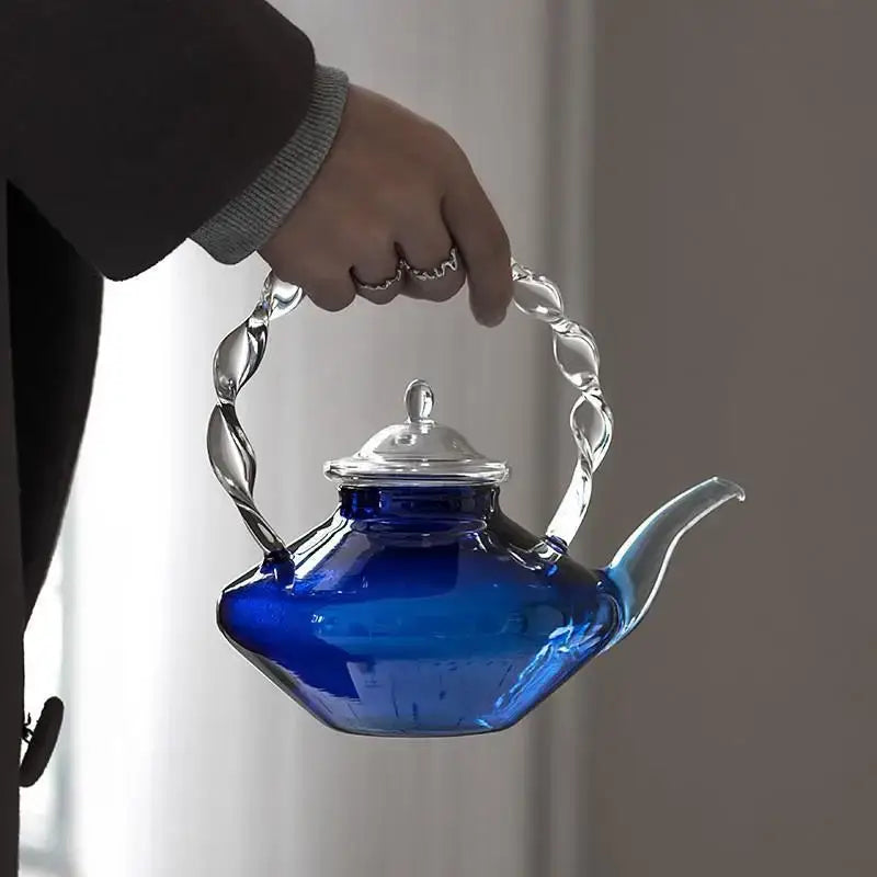 A vibrant cobalt blue glass teapot with twisted silver-toned metal handle and lid ideal for decorbites blue glass decor