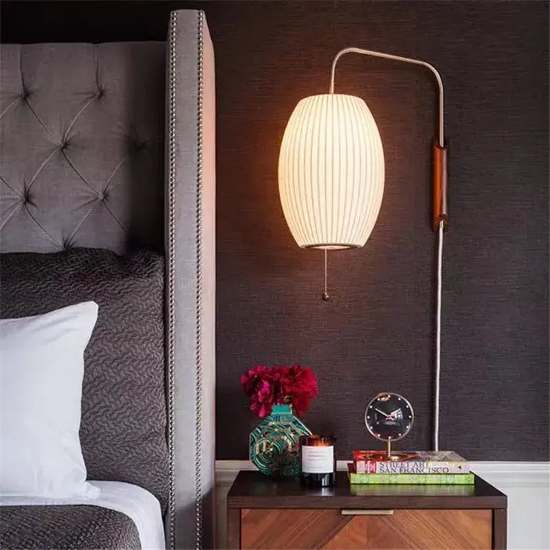 Cream-colored ribbed fabric wall light with a curved metallic arm and wooden accent from decorbites handwoven silk ball collection