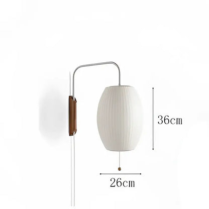 A sleek Japanese cream ribbed handwoven silk ball wall light with a metallic arm and wooden detail for bedroom decorbites