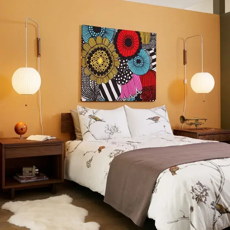 Vibrant abstract floral canvas art with bold red blue yellow and black patterns above a decorbites handwoven silk ball wall light
