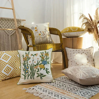 Cream-colored square pillow with intricate green yellow blue and orange floral linen embroidery for bedroom decorbites cotton linen decor
