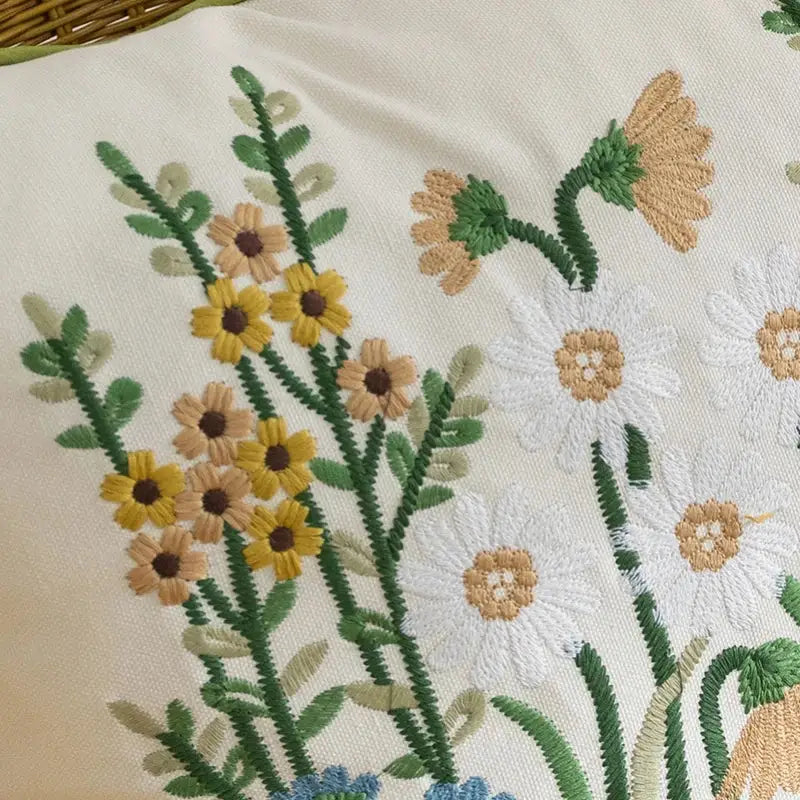 A cream-colored decorbites cotton linen pillowcase with yellow white and beige floral embroidery for bedroom decor