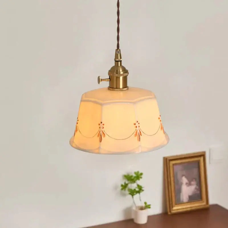 A warm-toned hexagonal ceramic led pendant light with gold floral patterns and brass fixture for living room decorbites ceramic led