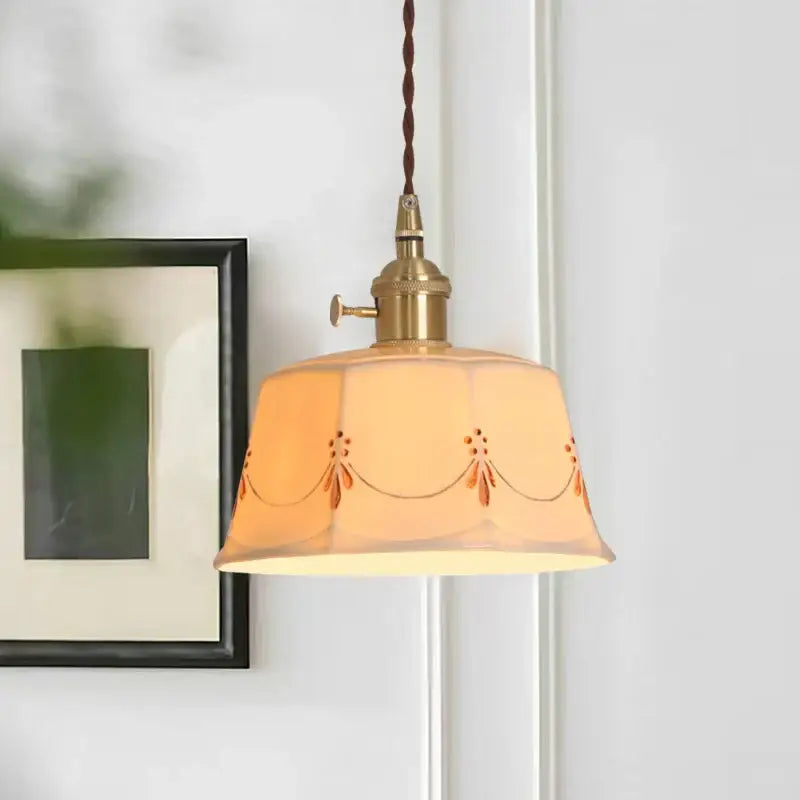 A warm amber ceramic led pendant light with orange floral embroidery and brass fixture for living room decorbites ceramic led
