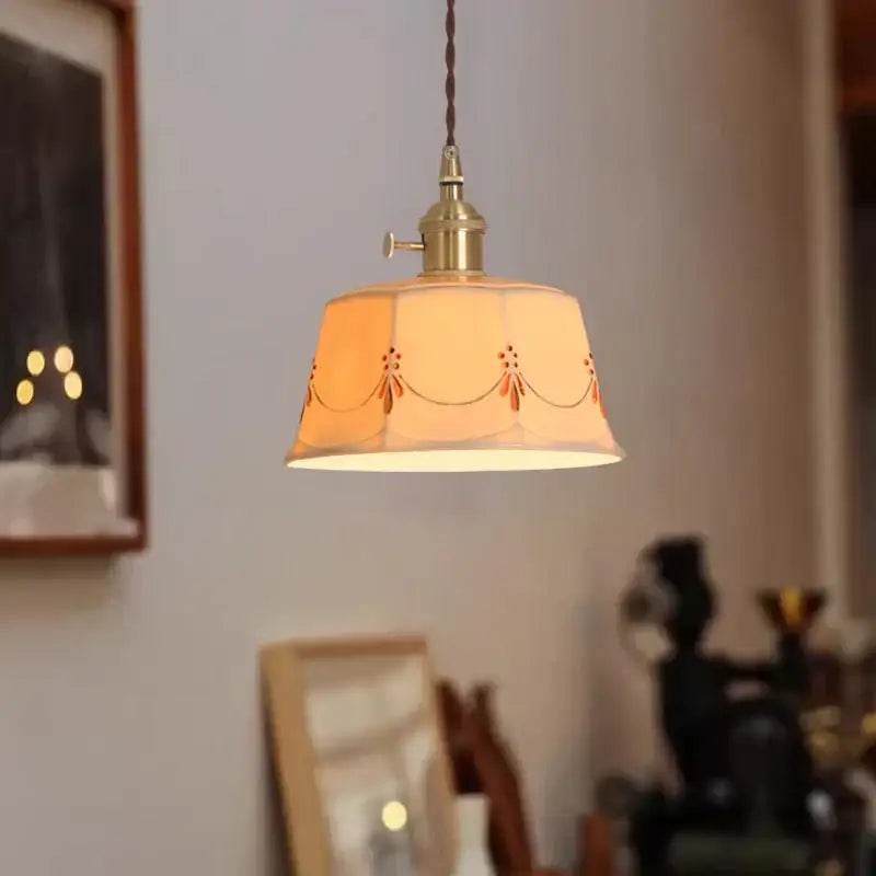 A warm-toned cream ceramic led pendant light with orange floral embroidery and brass fixture for living room decorbites ceramic led