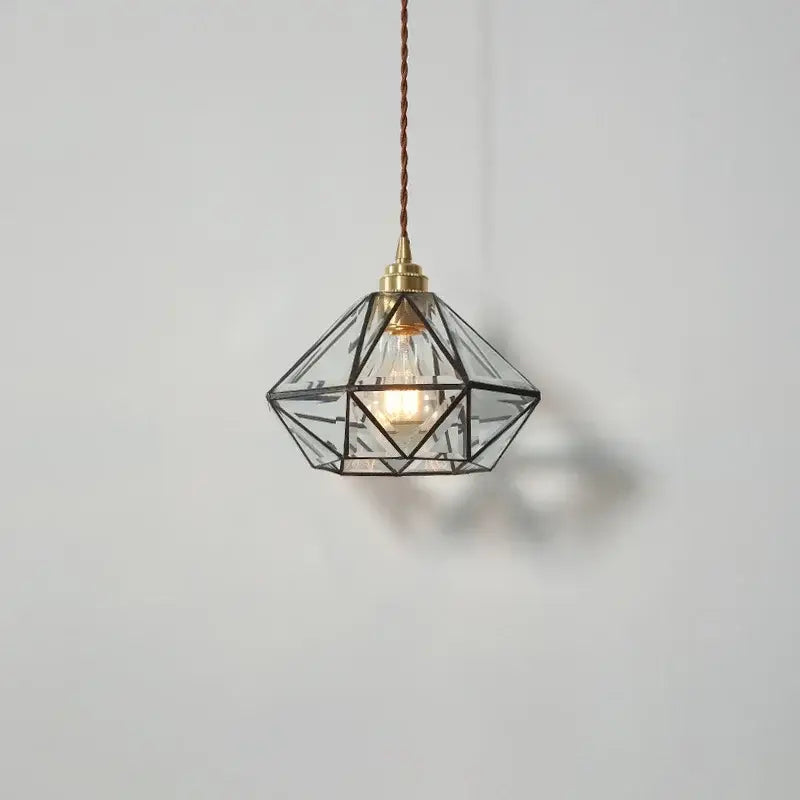 Japanese geometric glass led pendant lamp with brass-finished frame and exposed bulb suspended by twisted cord