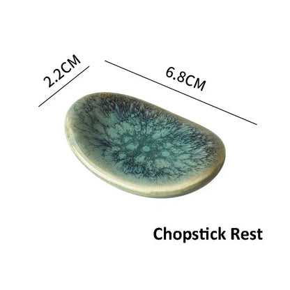 A glossy iridescent ceramic chopstick rest with teal and dark blue swirls from decorbites ceramic dinnerware set