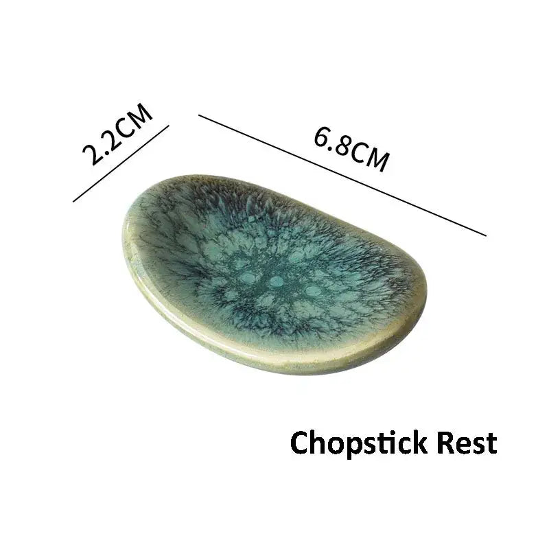 A glossy iridescent ceramic chopstick rest with teal and dark blue swirls from decorbites ceramic dinnerware set