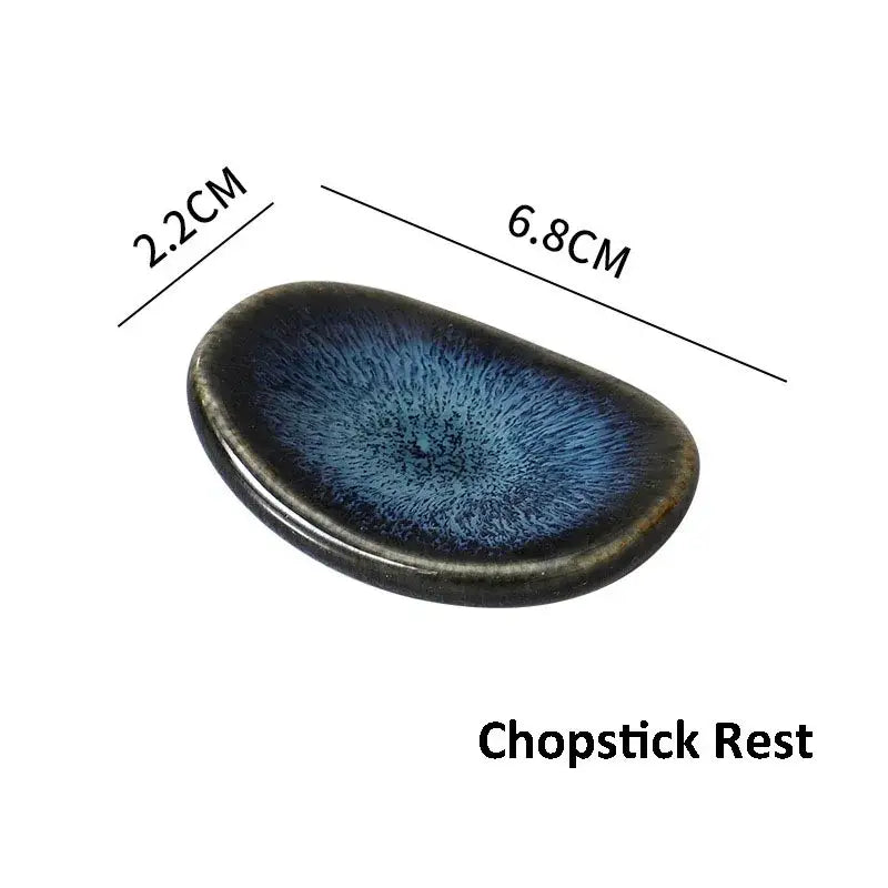 A sleek oval ceramic chopstick rest with dark blue glaze and feather pattern in the decorbites ceramic dinnerware set