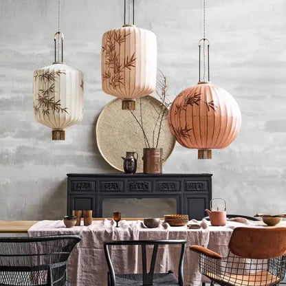 Three hanging japanese lanterns with bamboo leaf lantern painting in cream, peach, and beige fabric for dining room light