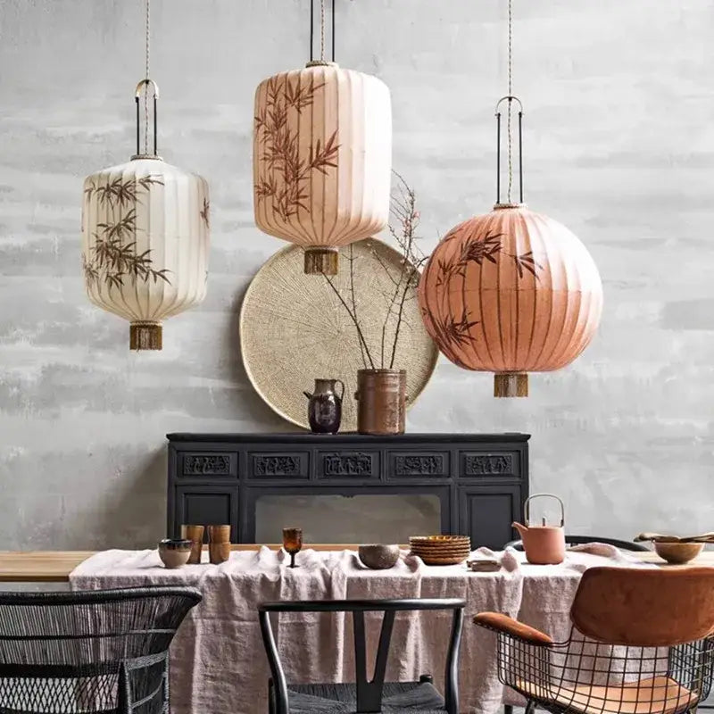 Three hanging japanese lanterns with bamboo leaf lantern painting in cream, peach, and beige fabric for dining room light