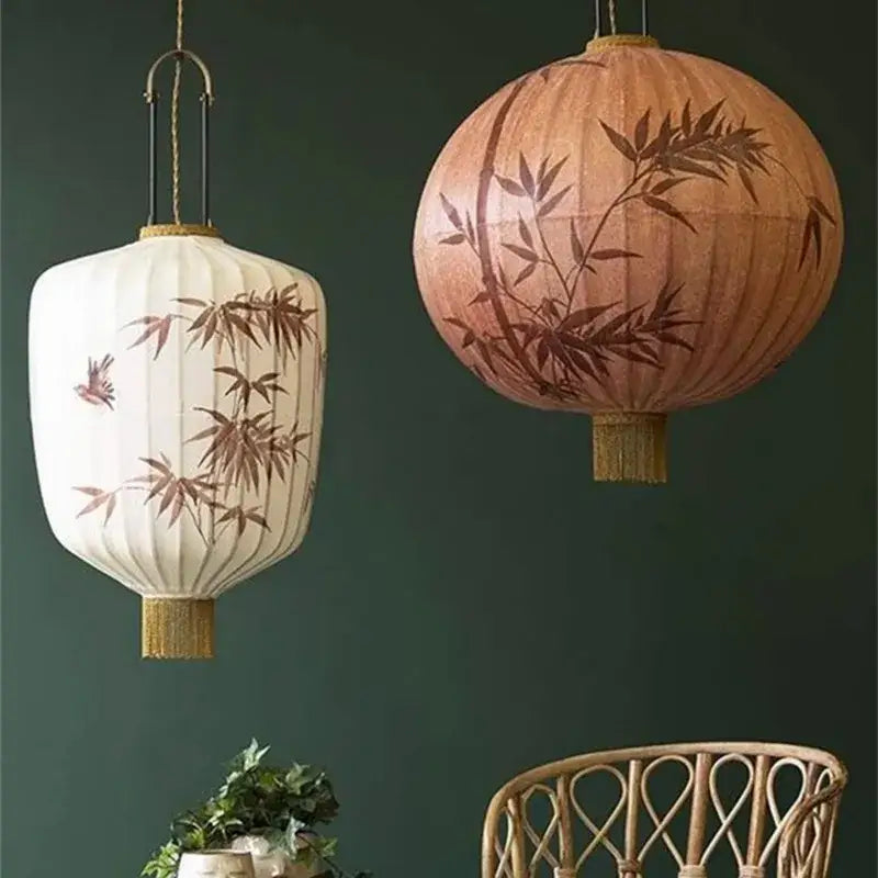 Two hanging japanese lantern paintings with cream and peach fabric featuring bamboo and bird motifs for dining room light