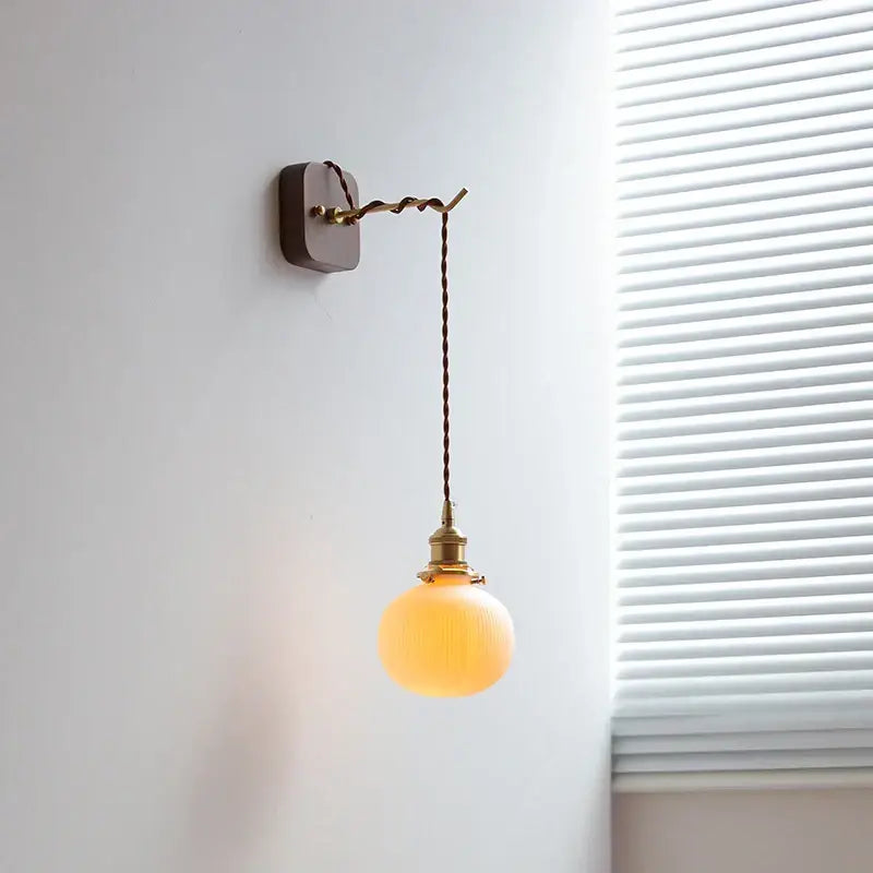 Warm amber glass globe wall light with brass hardware and twisted brown cord for decorbites ceramic led wall lighting