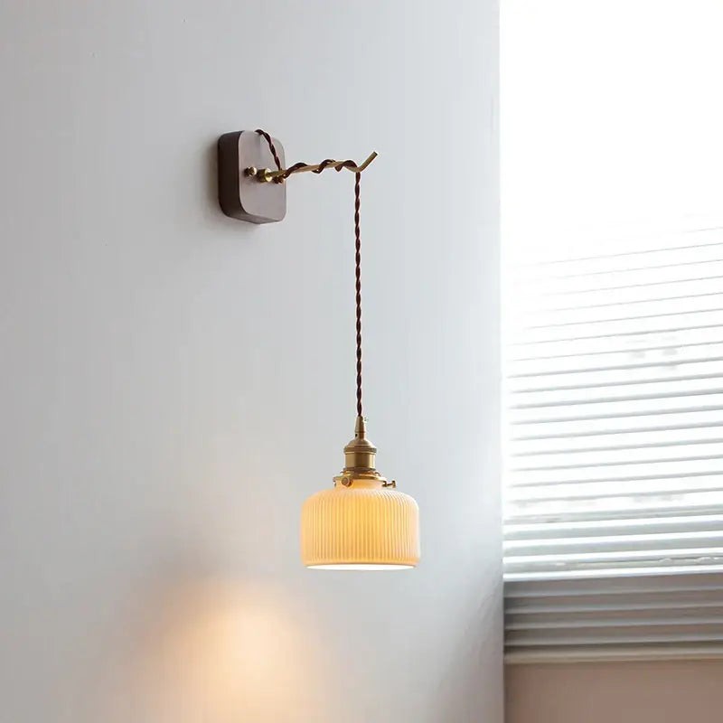 Japanese ribbed glass ceramic led wall light with warm tones brass accents and twisted cord for bedroom decorbites ceramic led wall