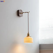A warm-toned Japanese ribbed glass ceramic led wall light with brass fixture and twisted cord for bedroom decorbites ceramic led wall
