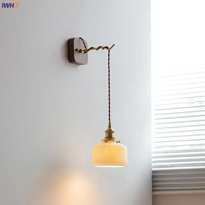 A warm-toned Japanese ribbed glass ceramic led wall light with brass fixture and twisted cord for bedroom decorbites ceramic led wall
