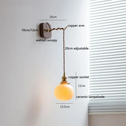 Warm-toned ceramic led wall light with brass socket and adjustable copper arm mounted on walnut canopy decorbites ceramic led
