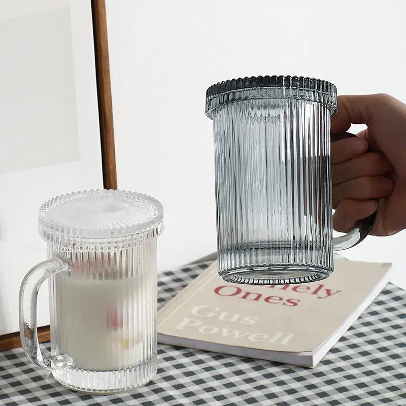 Clear glass ribbed coffee cup set with matching lid held by hand in decorbites glass coffee kitchen glassware