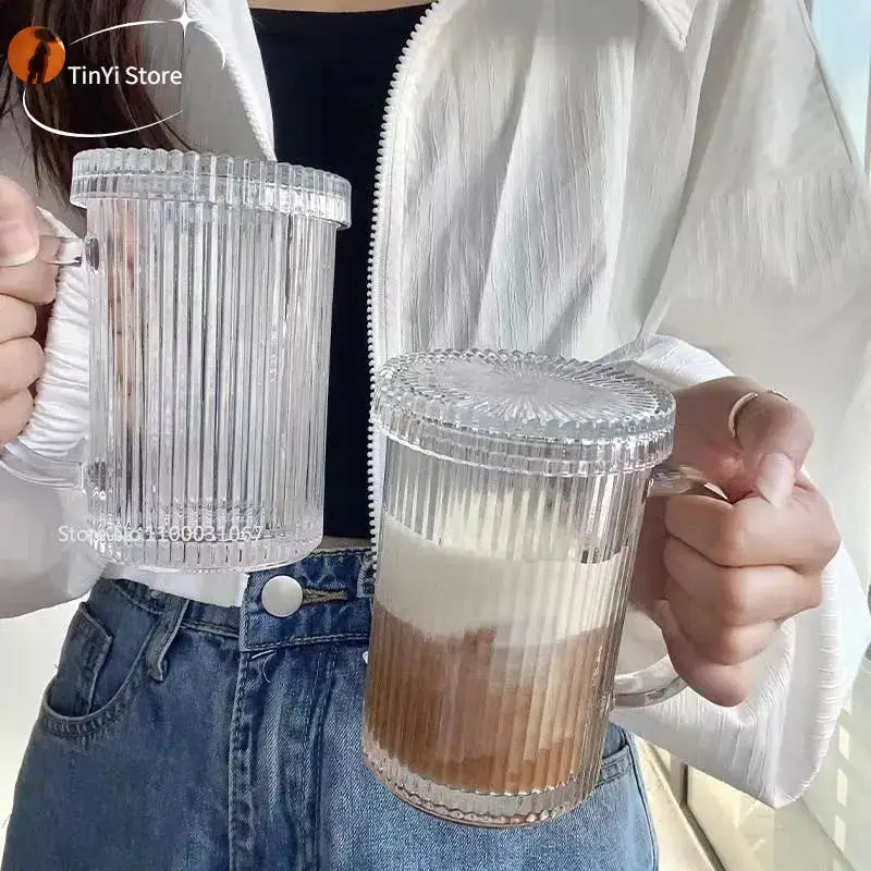 Clear ribbed glass coffee cup set with matching lids and handles featuring a layered beverage decorbites glass coffee