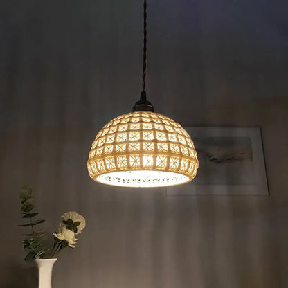 A warm glowing ceramic pendant light with a woven rattan shade and geometric lattice for kitchen or dining room