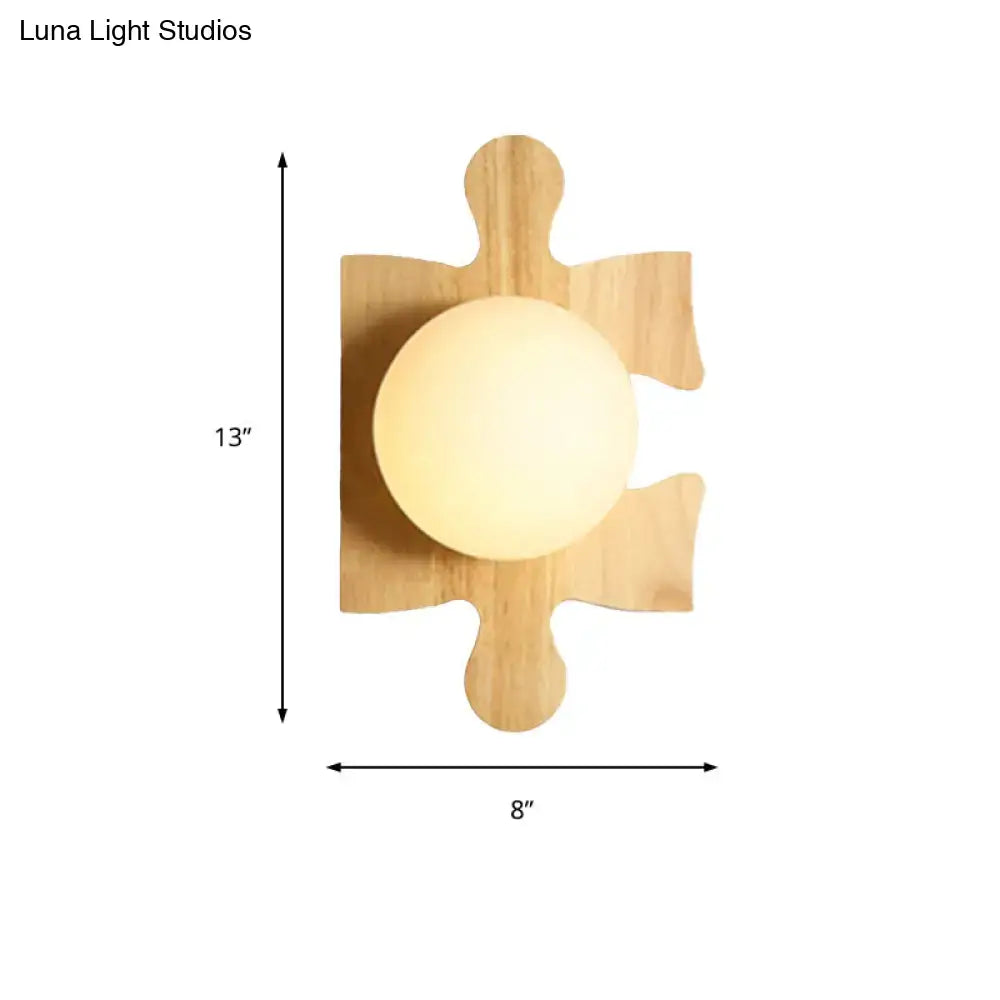 A warm beige wall light with a softly glowing spherical fixture mounted on a natural wooden puzzle base