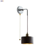 Black cylindrical wall lamp with brass pull chain metal fixture ideal for stair light fixtures in Japanese style