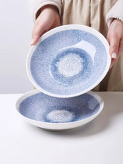 Japanese style blue and white ceramic deep dish bowl with blue speckles white rim and concentric circular pattern