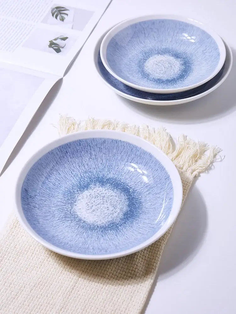Japanese style blue and white ceramic deep dish bowl with radial textured glaze pattern and white rims for dining use