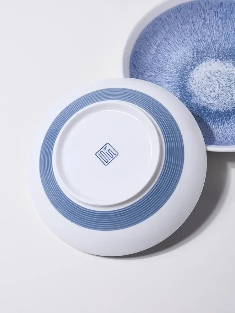 Japanese style blue and white ceramic deep dish bowl with concentric blue stripes and a small square center logo